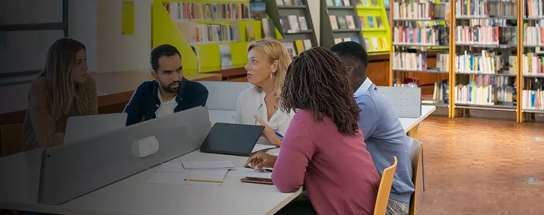 Students discussing their work in a university library